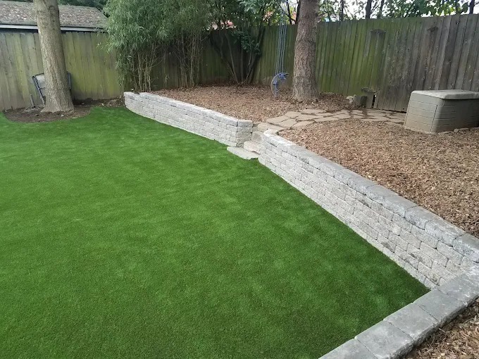 Artificial turf lawn bounded by a low block retaining wall