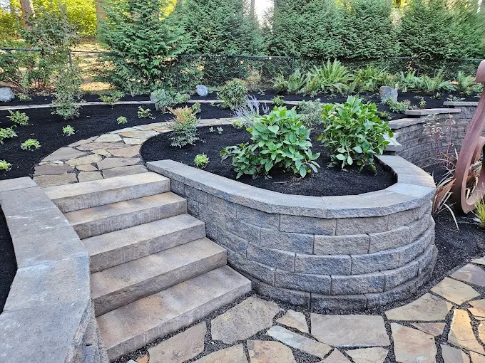 Curved stone planter wall with hydrangeas and flagstone steps
