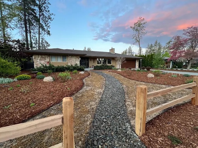 Gravel dry creek bed winding through front yard planting beds