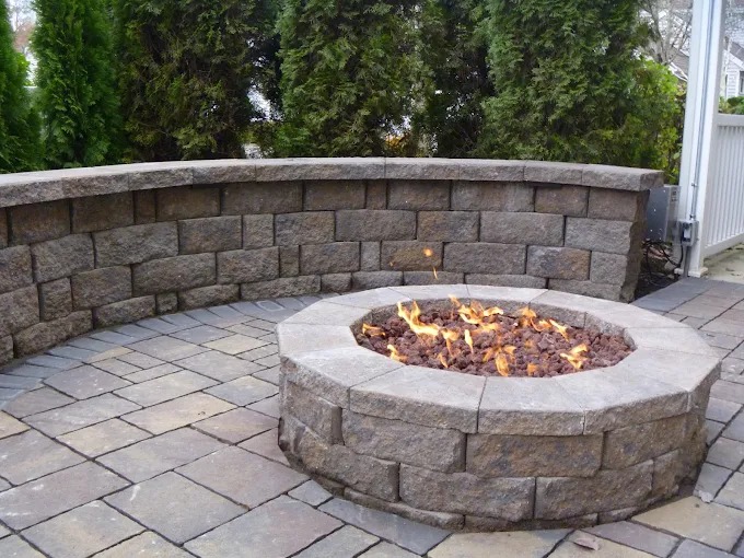 Stone fire pit with seat wall on a paver patio