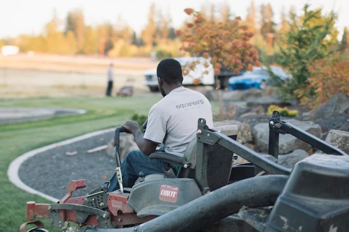 Crew member on a zero-turn mower at a commercial property